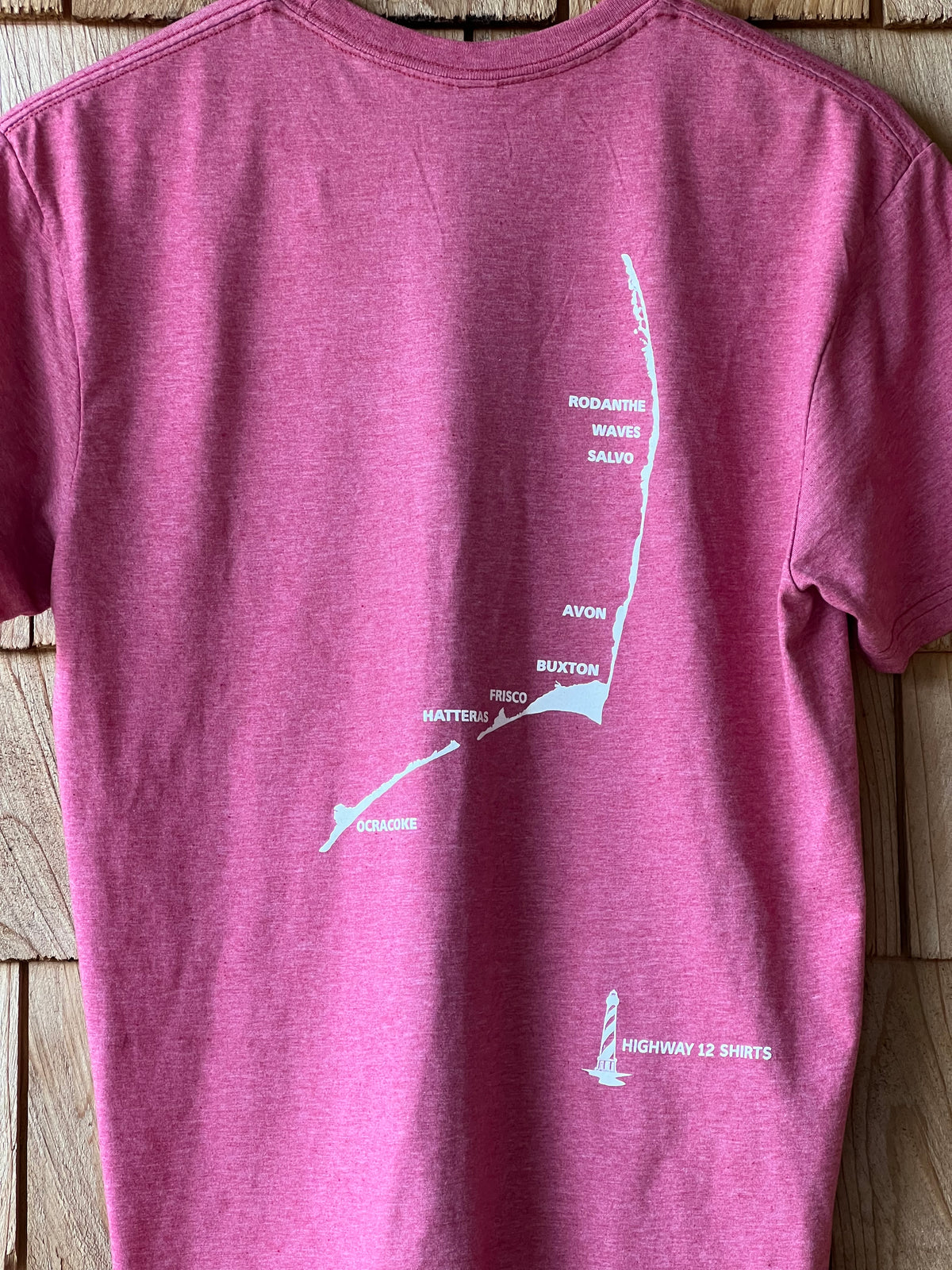Purple t-shirt with a white graphic on a wooden surface