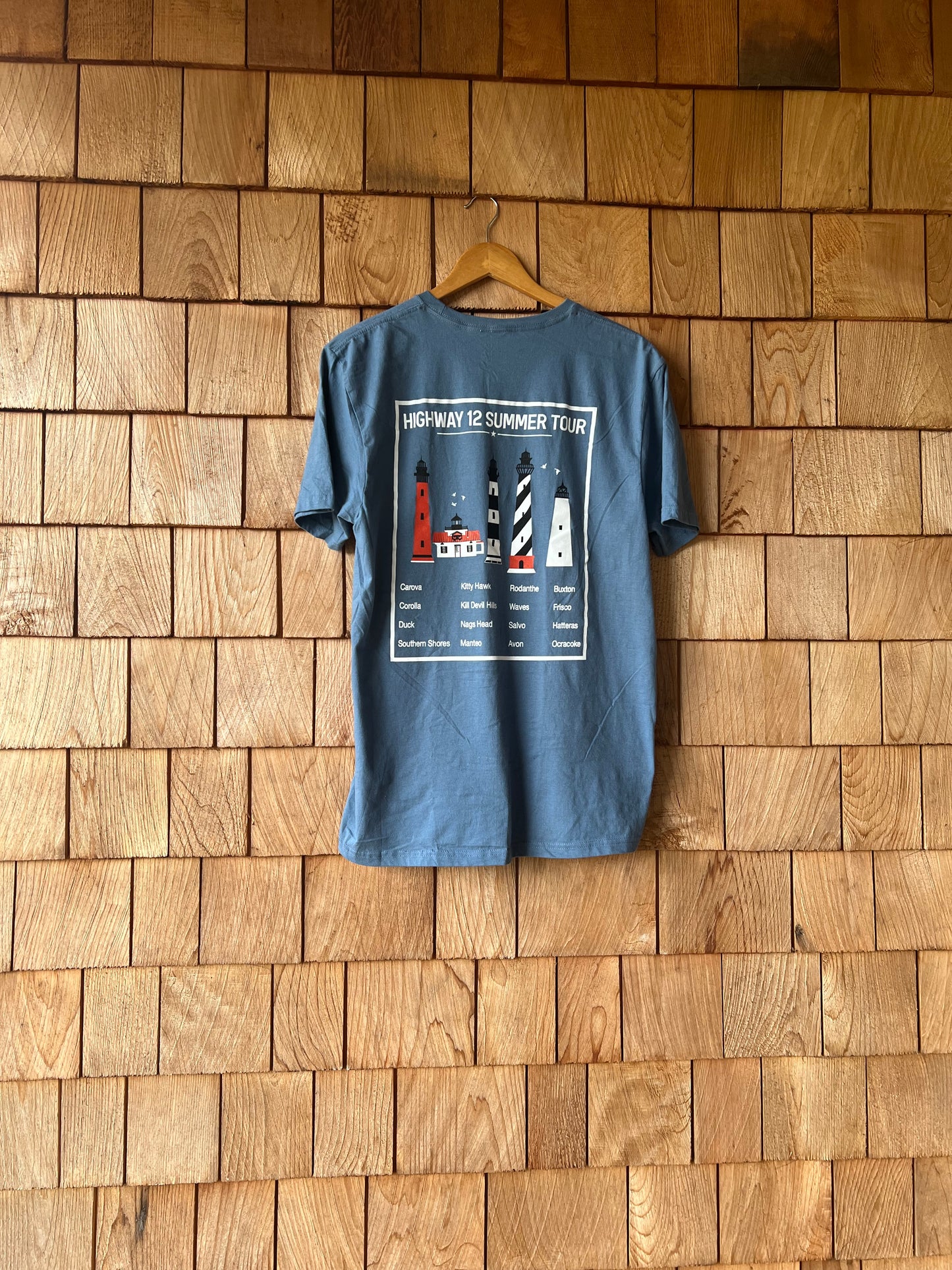 Blue t-shirt with a graphic design on a wooden wall