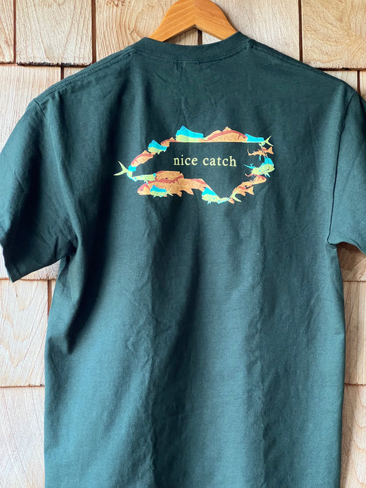 Green t-shirt with a colorful graphic and text on a wooden surface