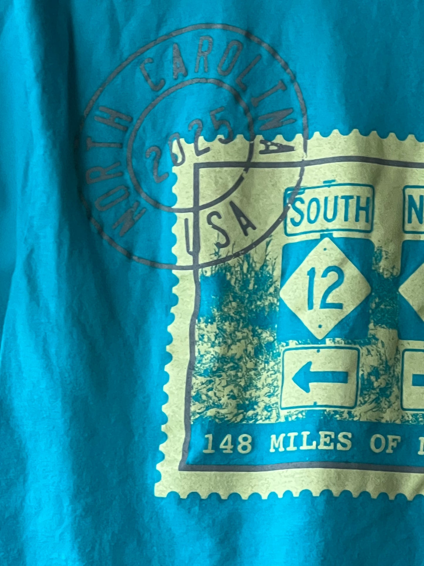 Close-up of a blue and gold road sign with a stamp on a blue background