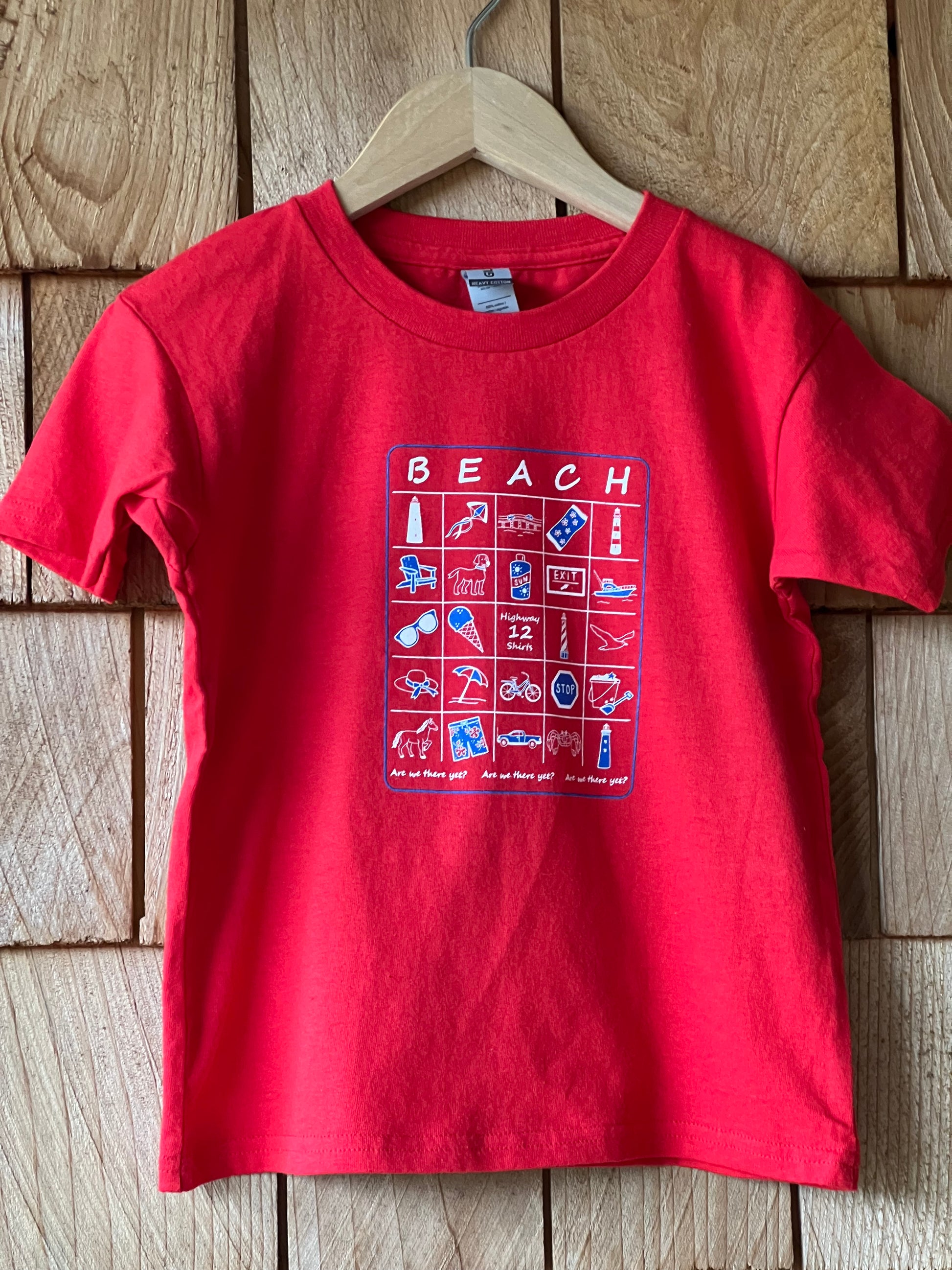 Red t-shirt with a graphic design on a wooden surface