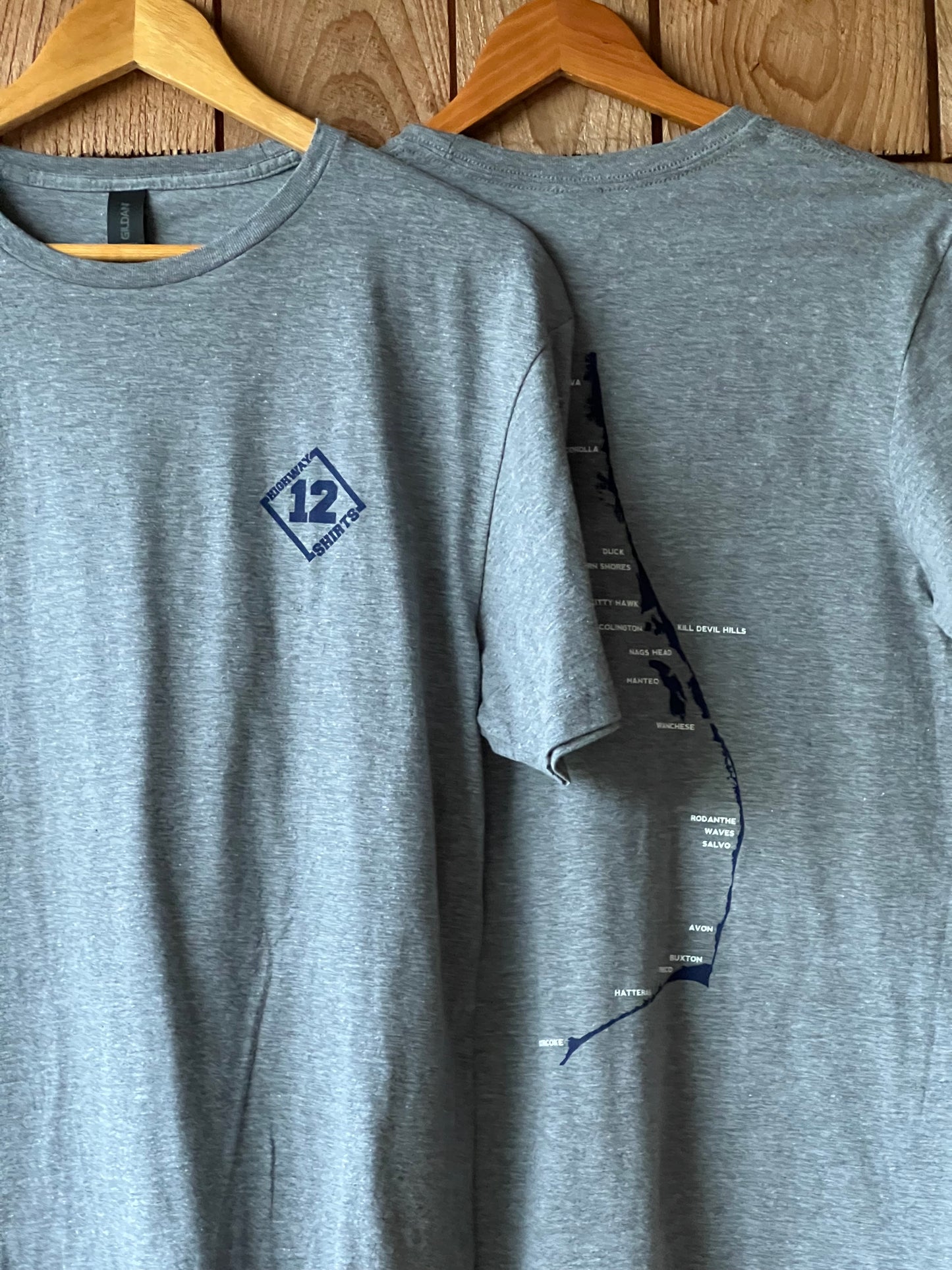 Gray t-shirt with a logo on a wooden surface