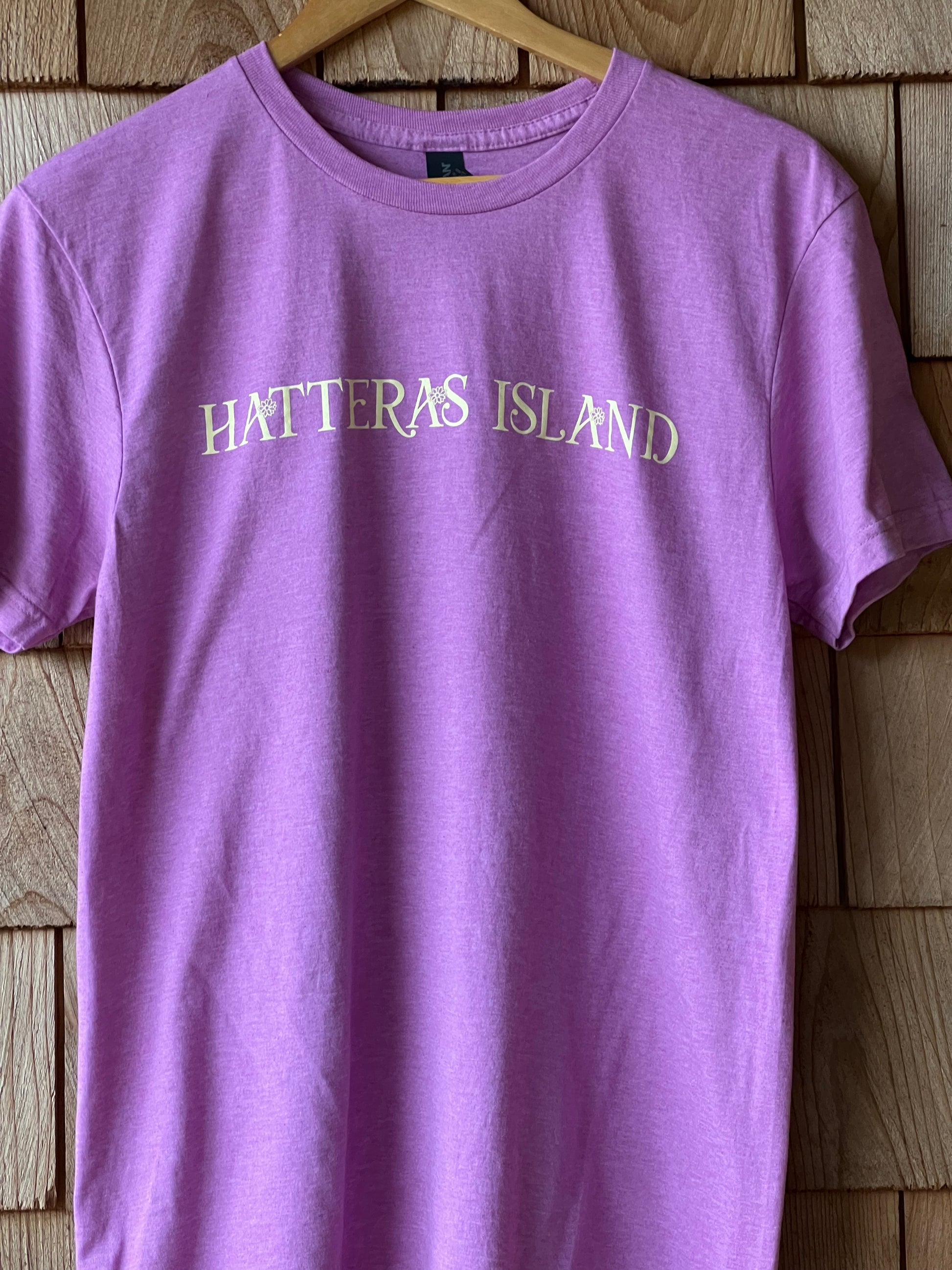 Purple t-shirt with 'Hatteras Island' text on a wooden surface