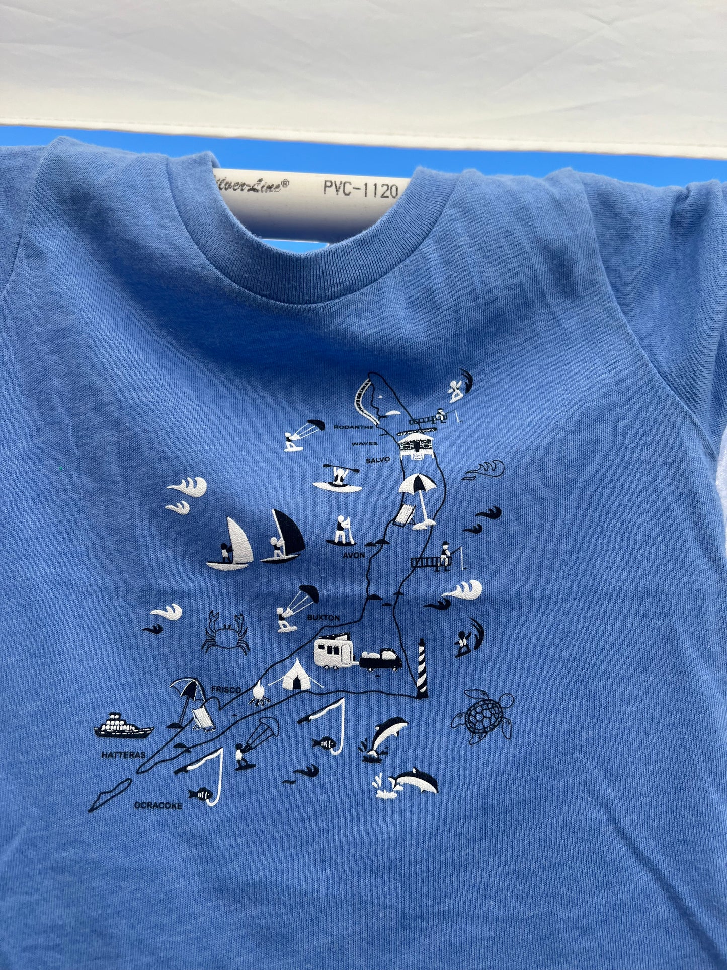 Blue t-shirt with black nautical-themed graphics on a blue background