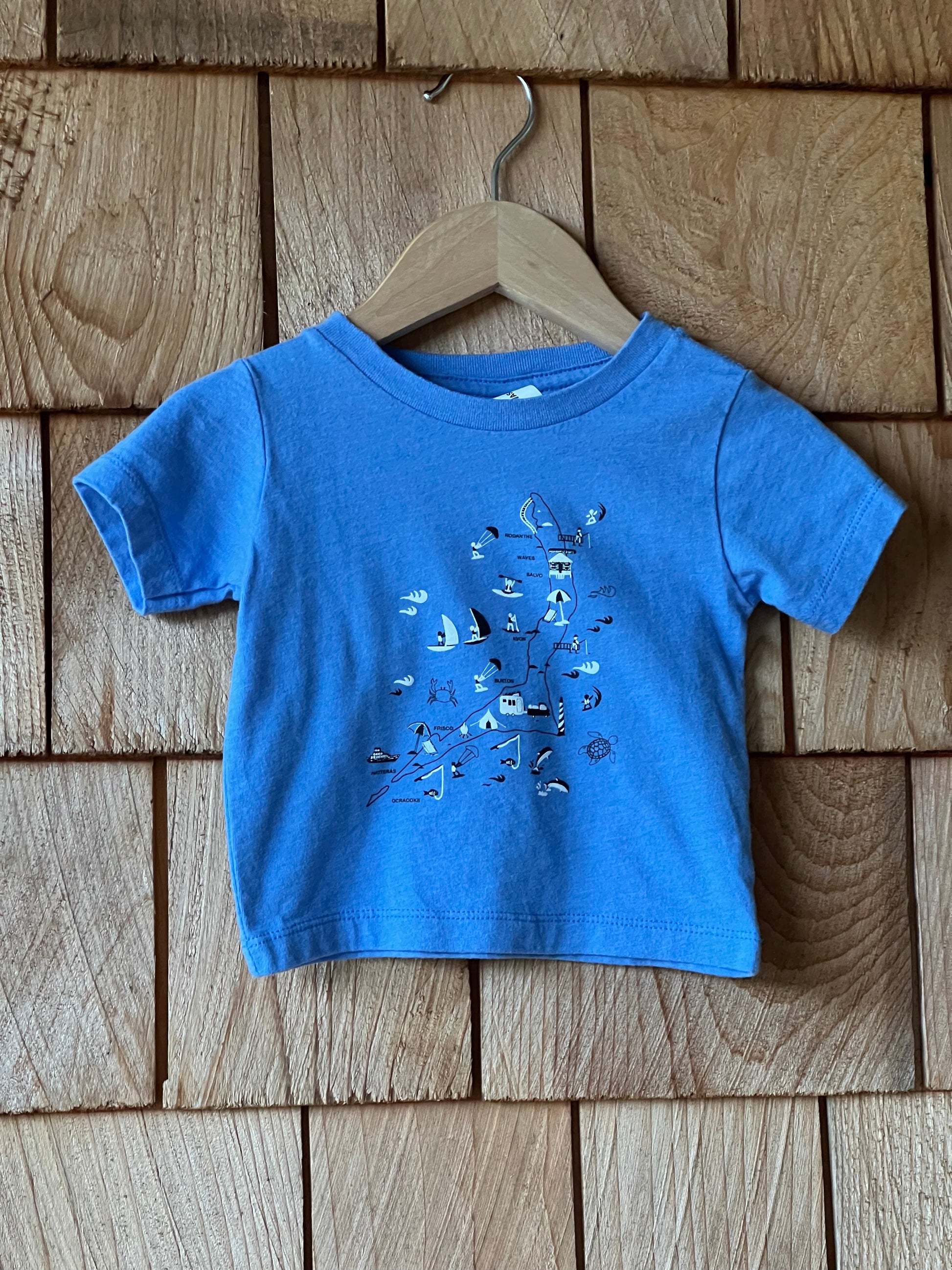 Blue t-shirt with a design on a wooden surface