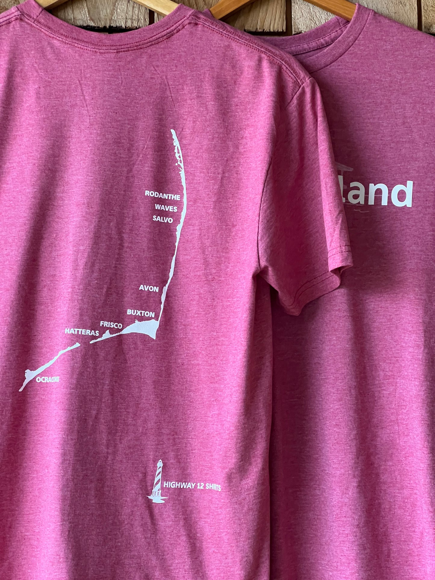 Purple t-shirt with white text and graphics on a wooden surface