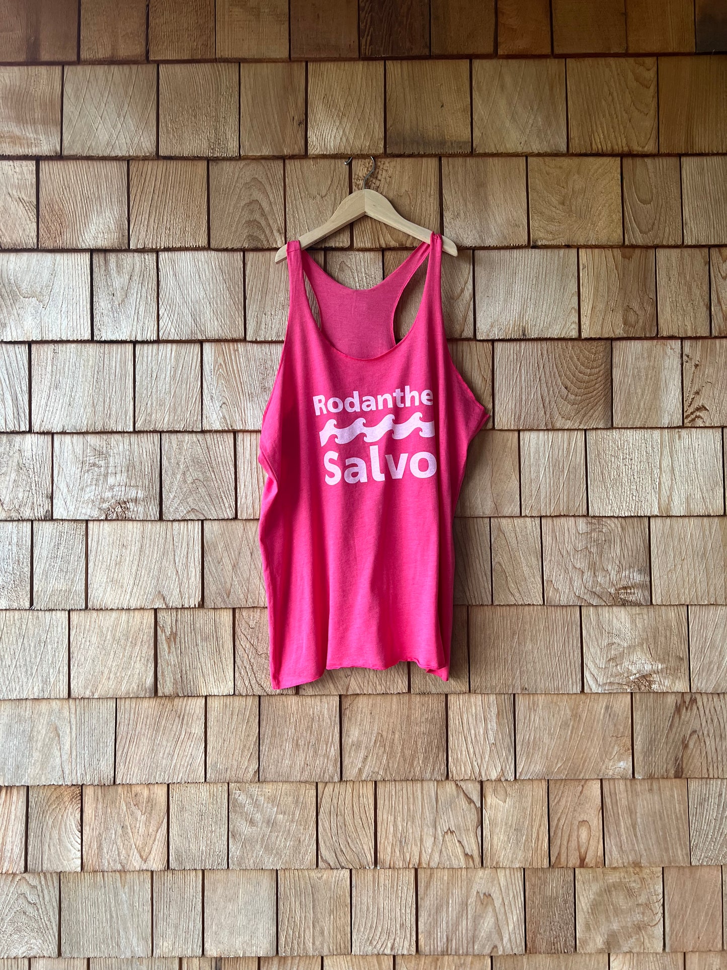 Pink tank top with visible branding on a wooden floor