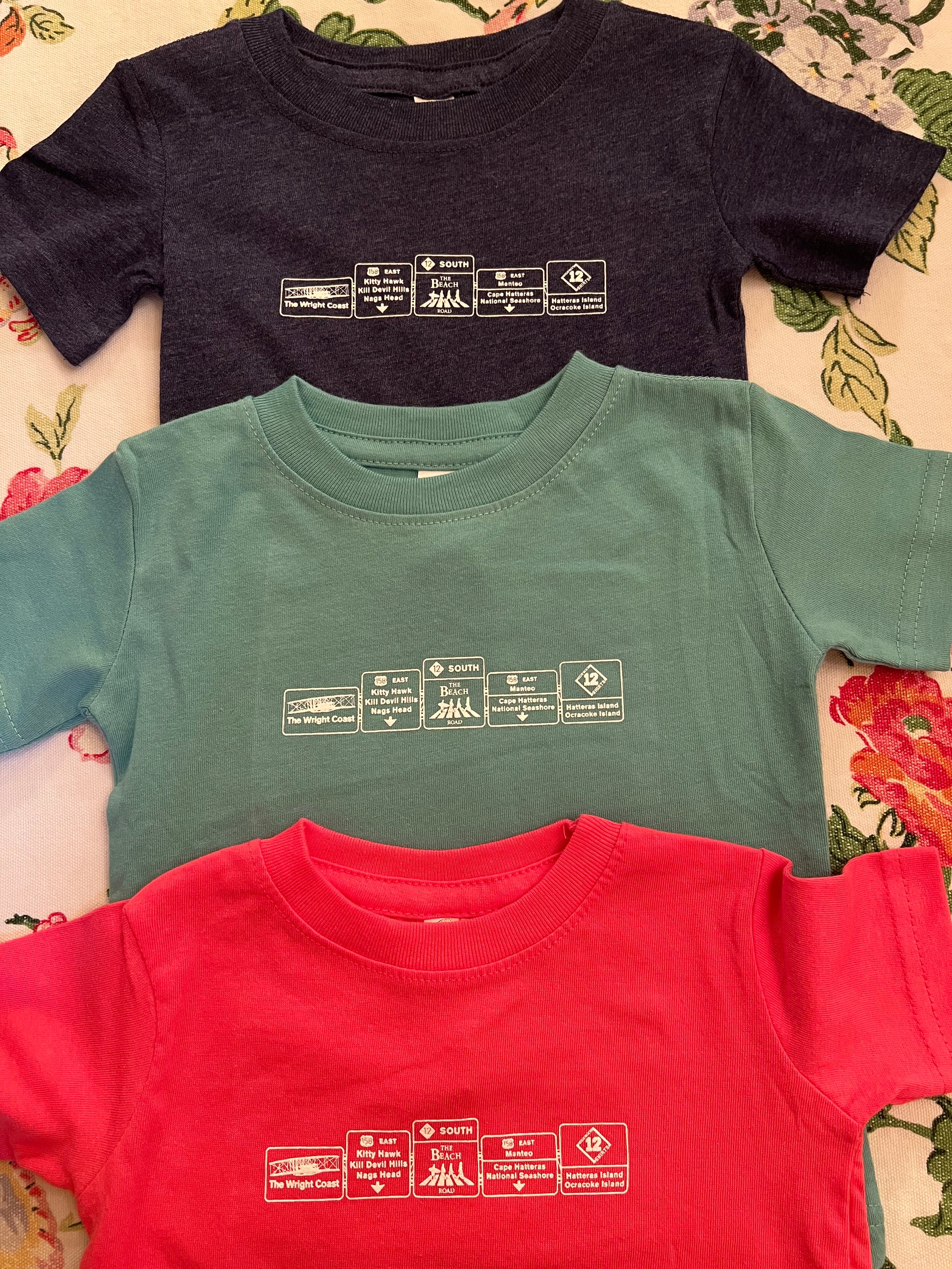 Welcome to the Outer Banks of North Carolina sign on a infant short sleeve screen-printed shirt.