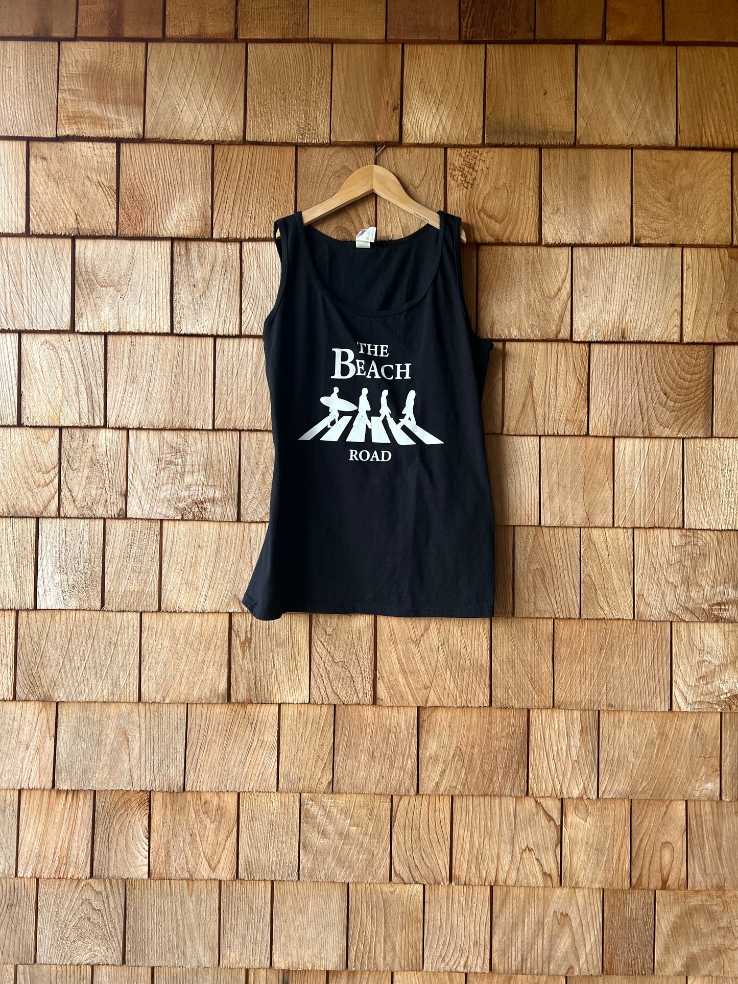 Black tank top with white text on a wooden surface