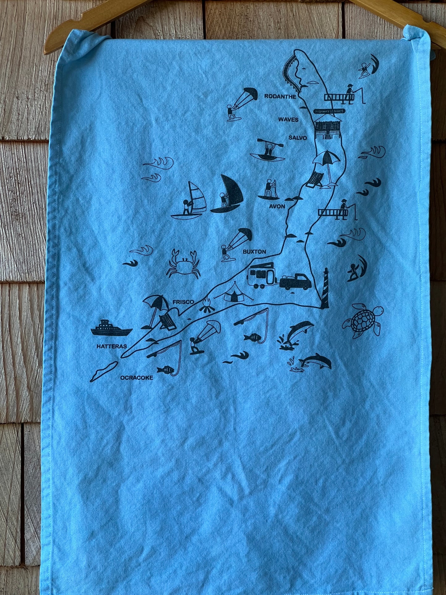 Blue towel with black illustrations of a map on a wooden surface