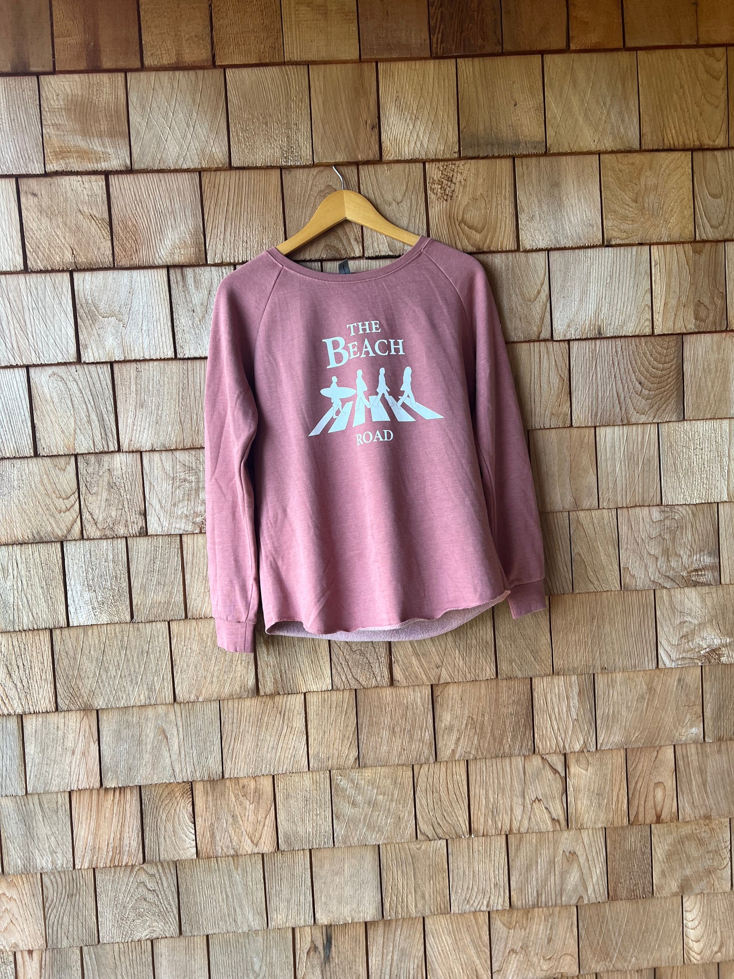 Pink t-shirt with text on a wooden floor
