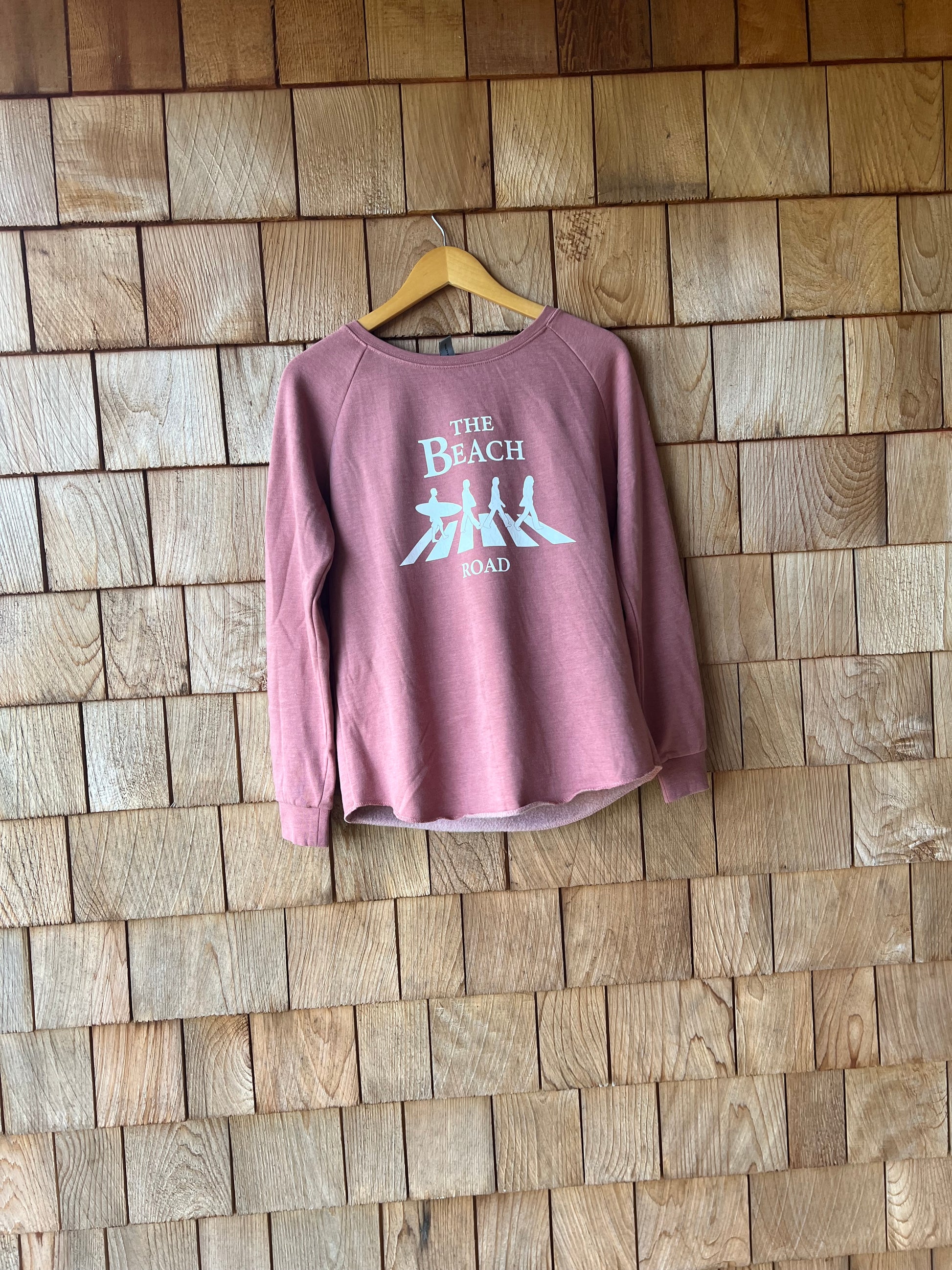 Pink t-shirt with text on a wooden floor
