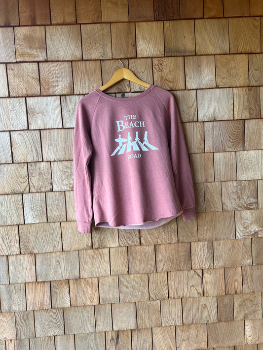 Pink t-shirt with text on a wooden floor