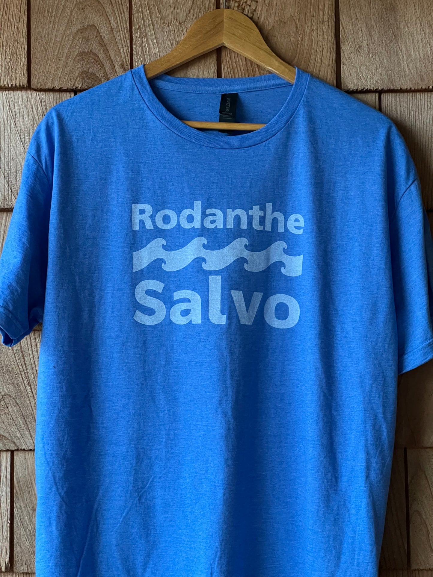 Blue t-shirt with 'Rodanthe Salvo' logo on a wooden surface