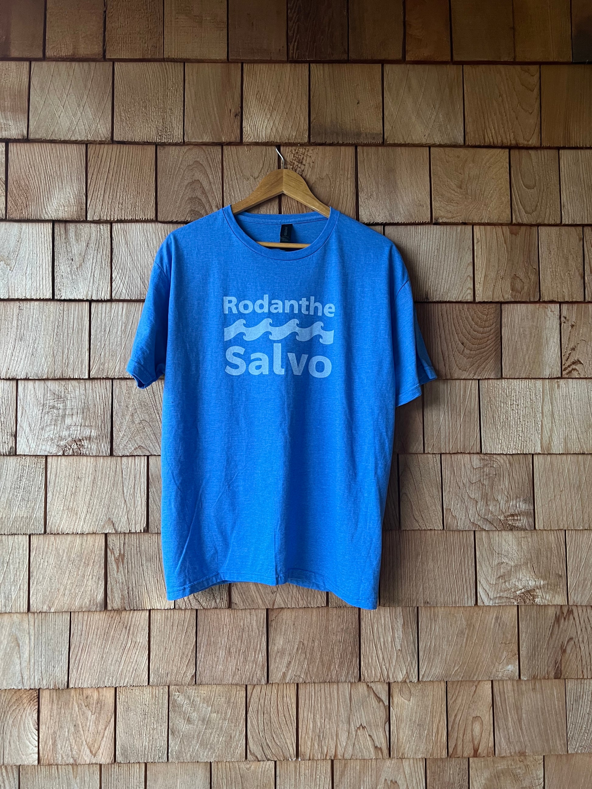 Blue t-shirt with 'Rodanthe Salvo' text on a wooden floor