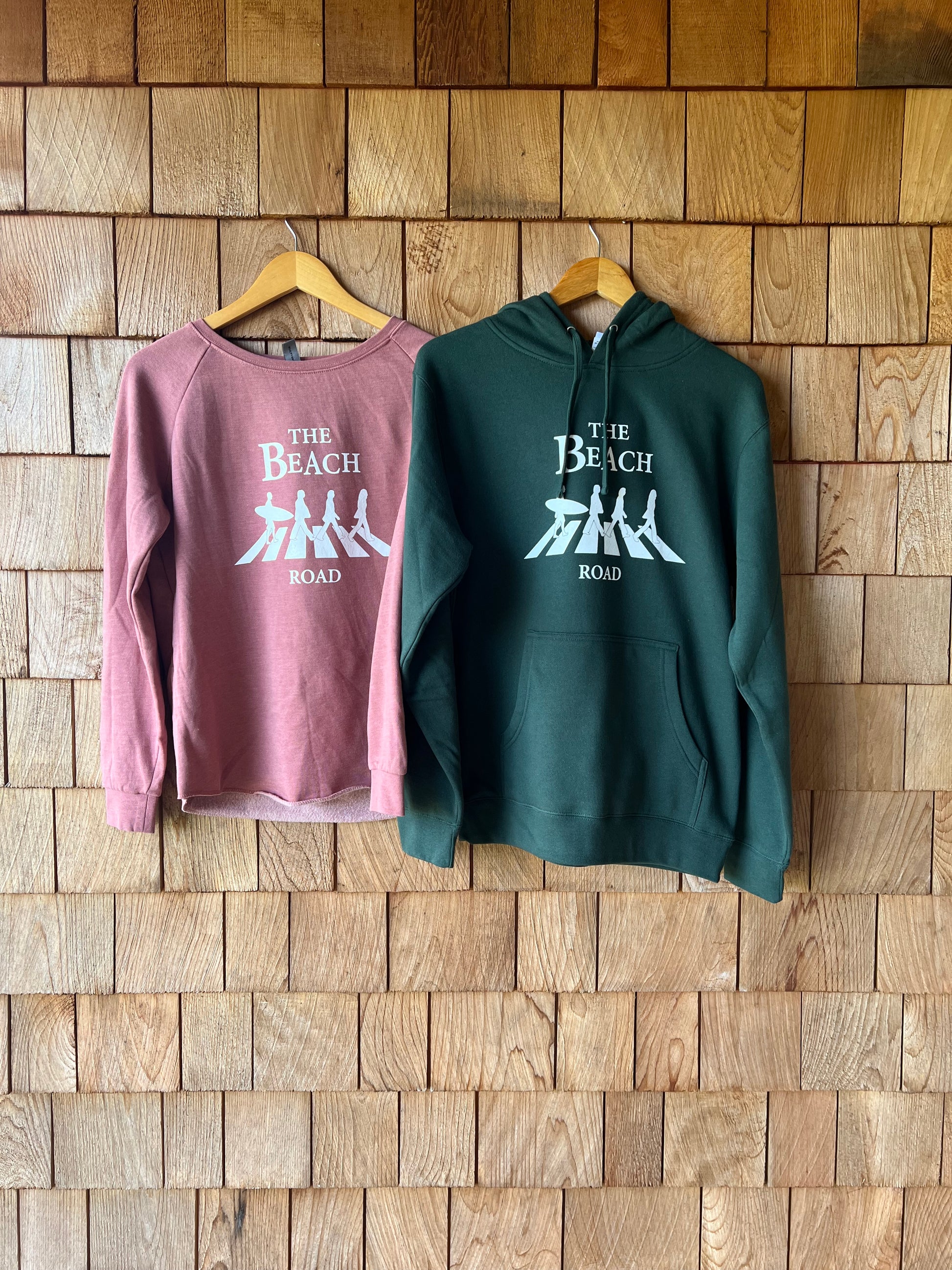 Green hoodie and pink tank top with text on a wooden surface