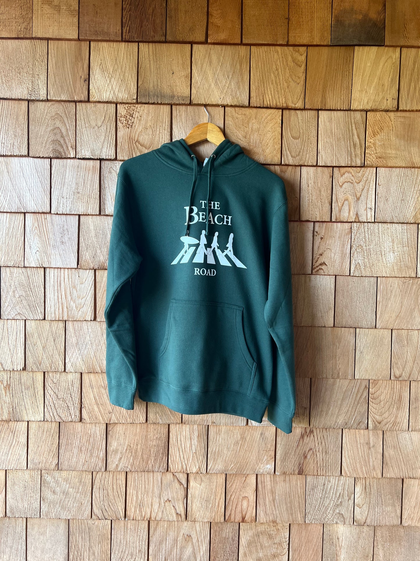 Green hoodie with text on a wooden wall