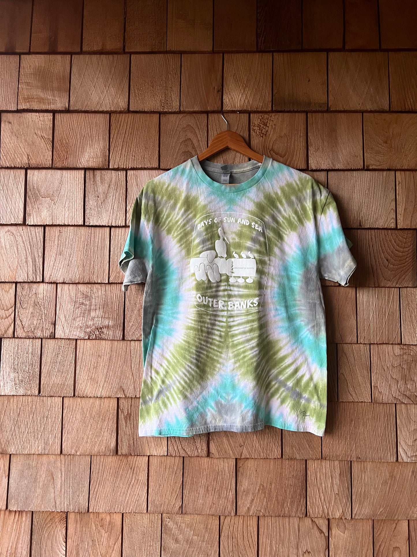 Tie-dye shirt with text on a wooden wall
