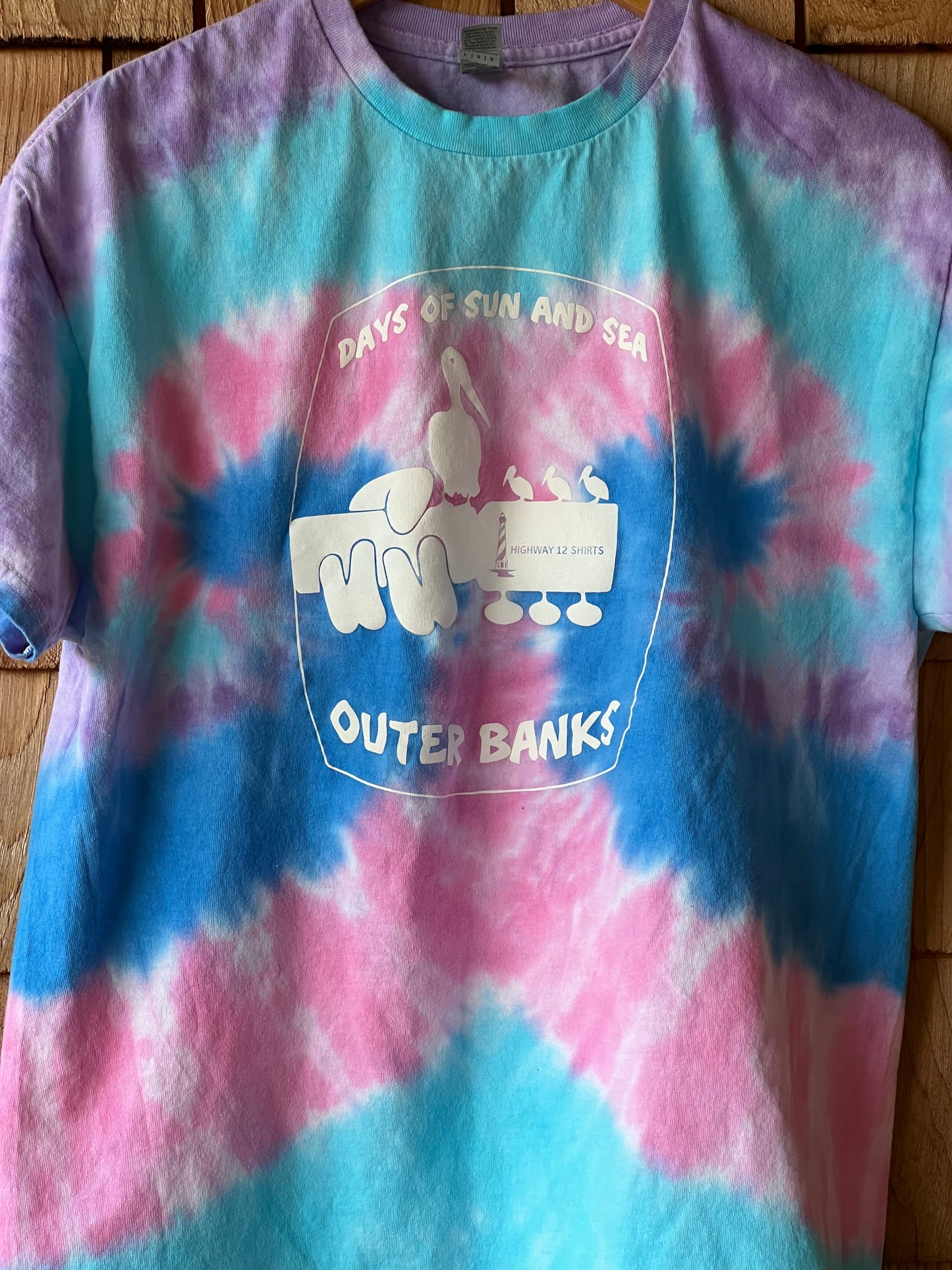 Tie-dye t-shirt with a logo on a wooden surface