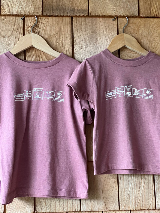 Two purple tank tops with labels on a wooden surface