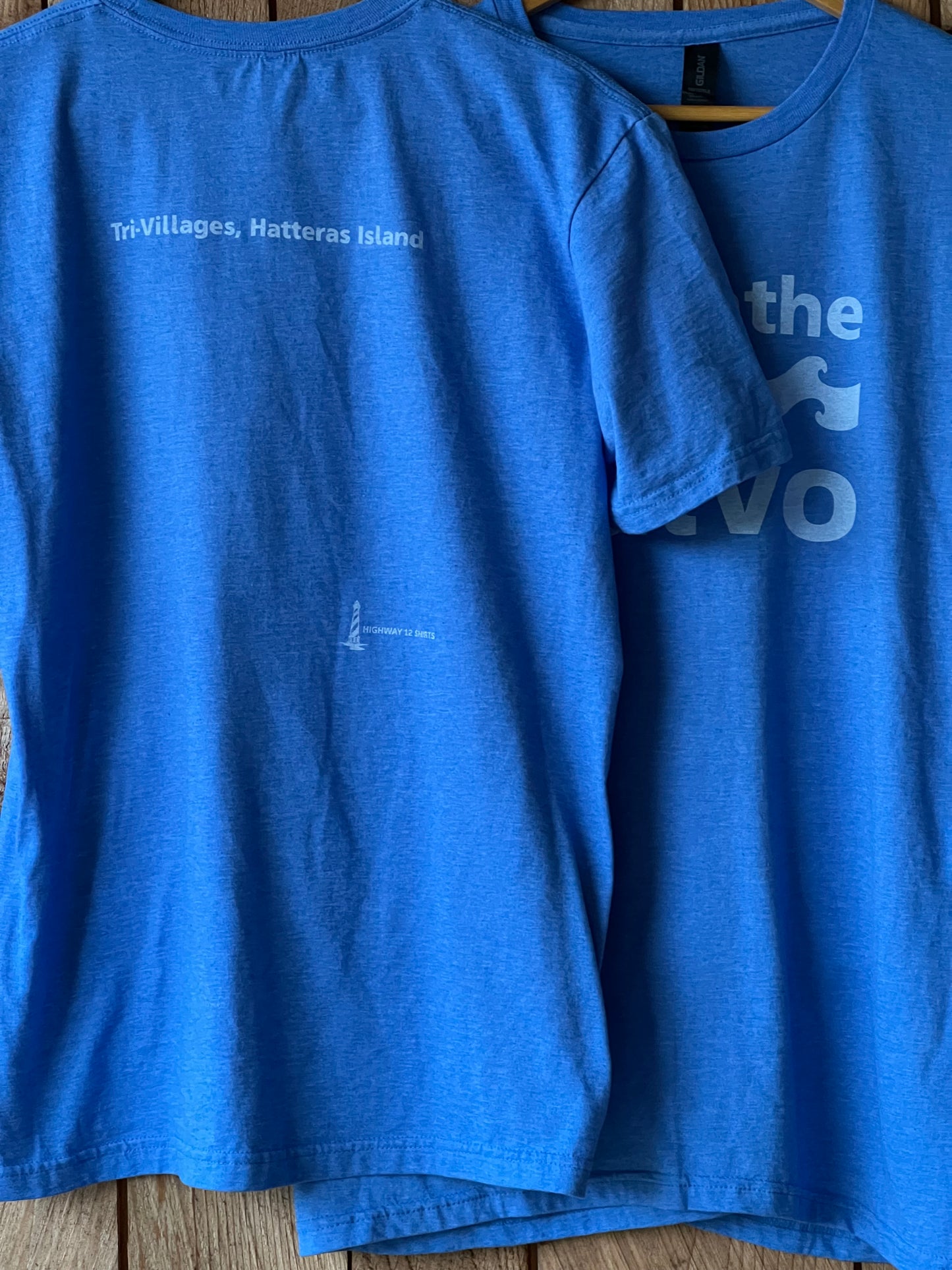 Blue t-shirt with text on a wooden surface