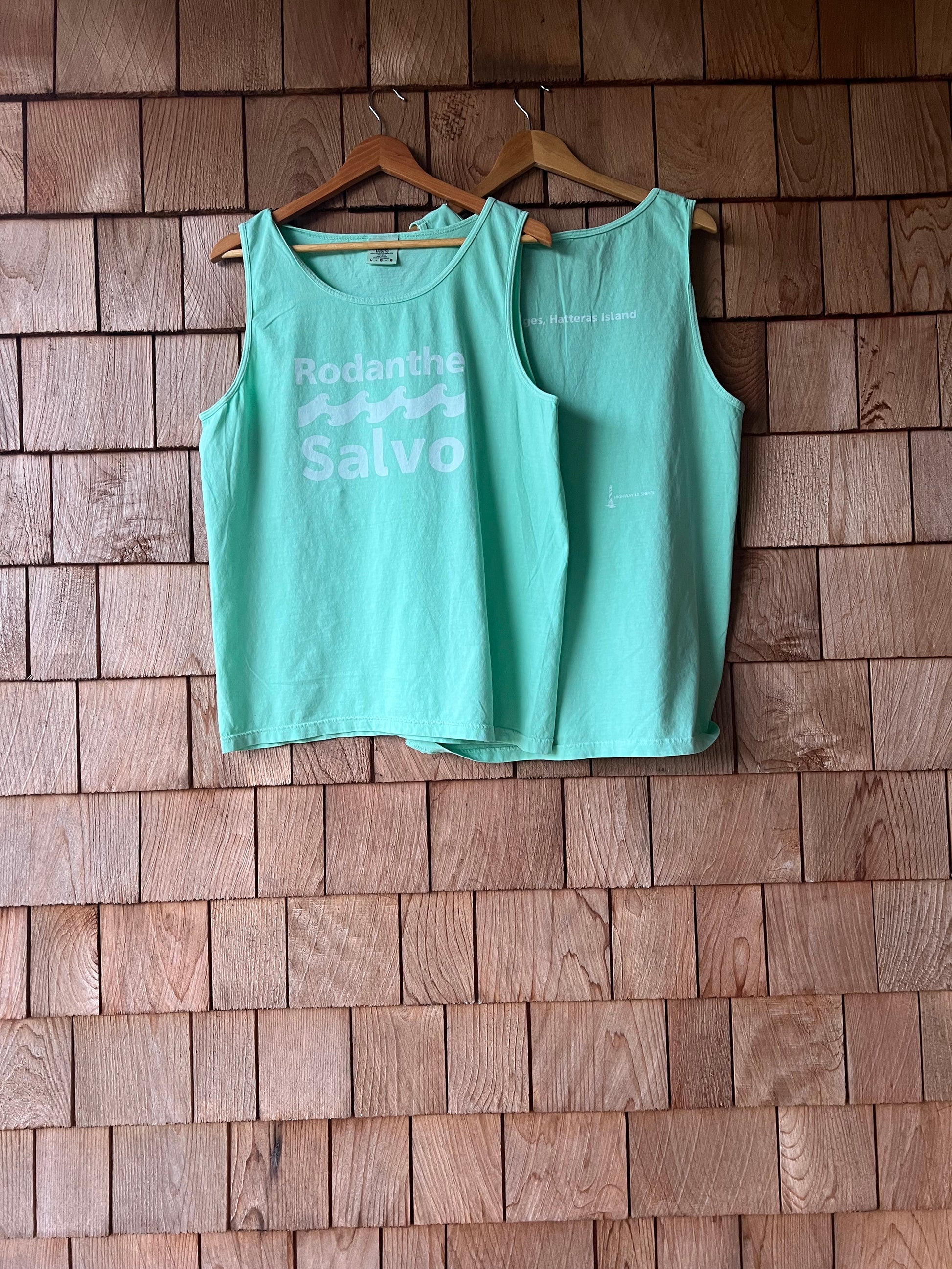 Green t-shirt with text on a wooden floor