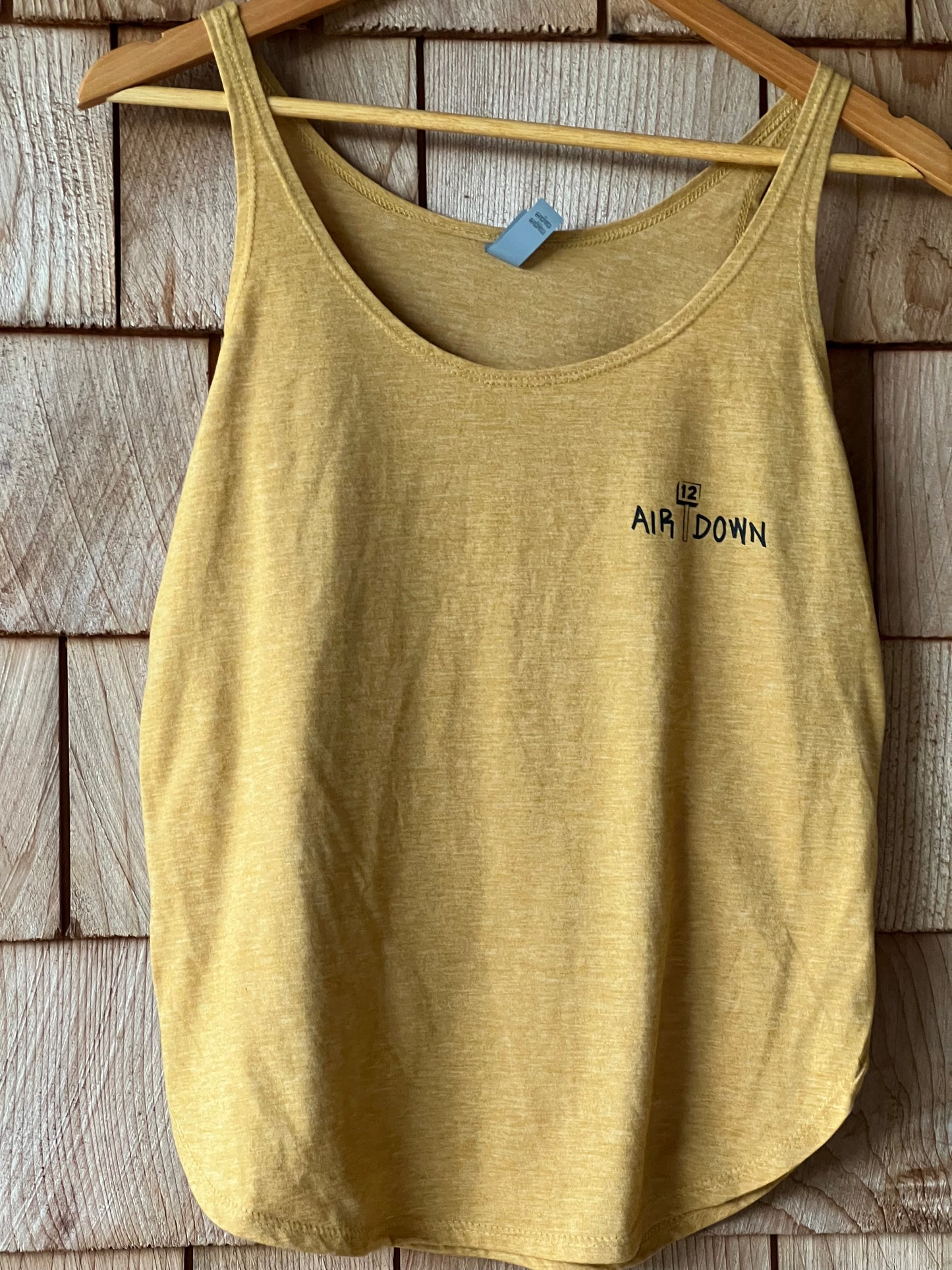 Yellow tank top with 'AIR DOWN' branding on a wooden surface