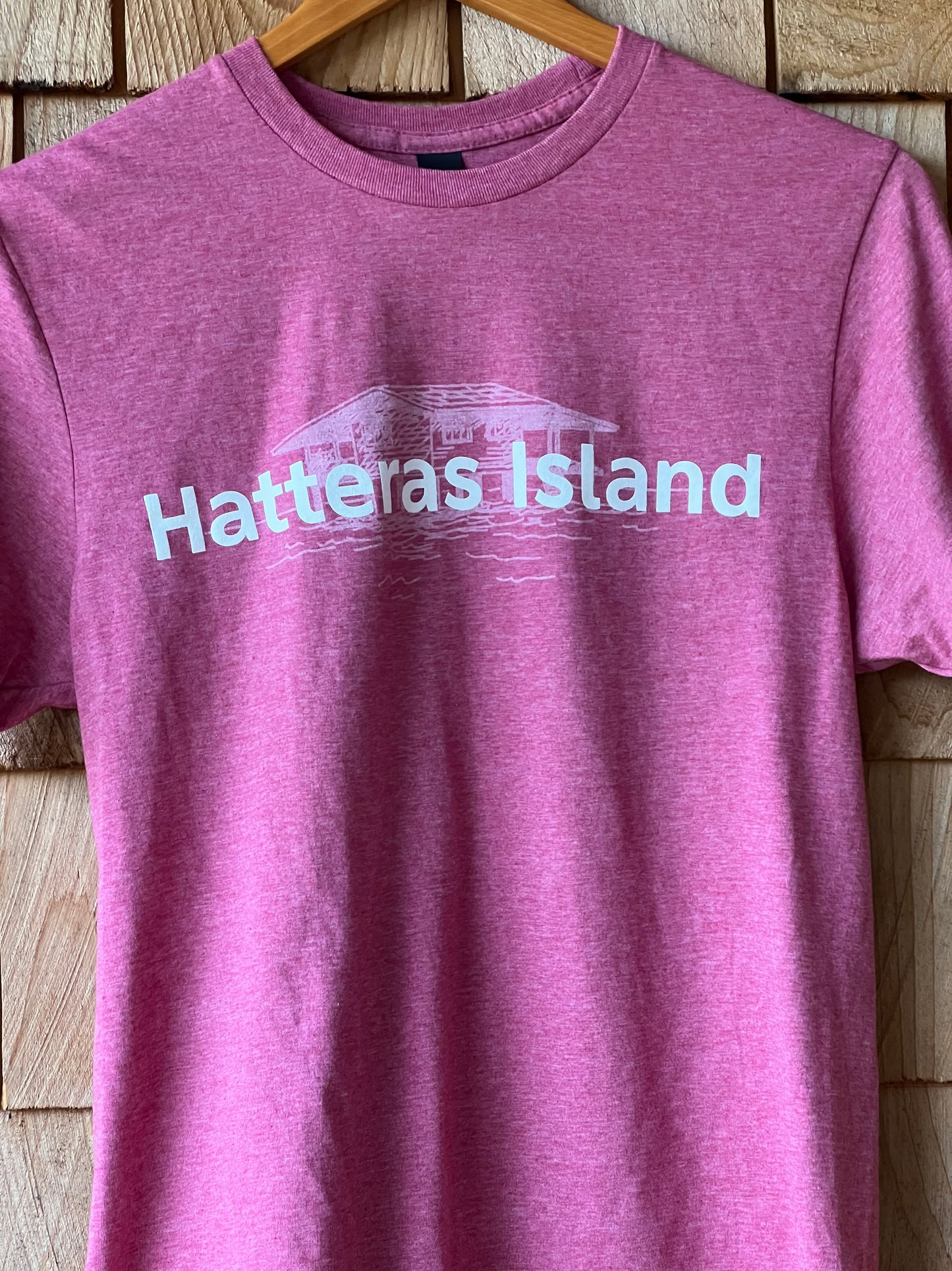 Purple t-shirt with 'Hatteras Island' text on a wooden surface