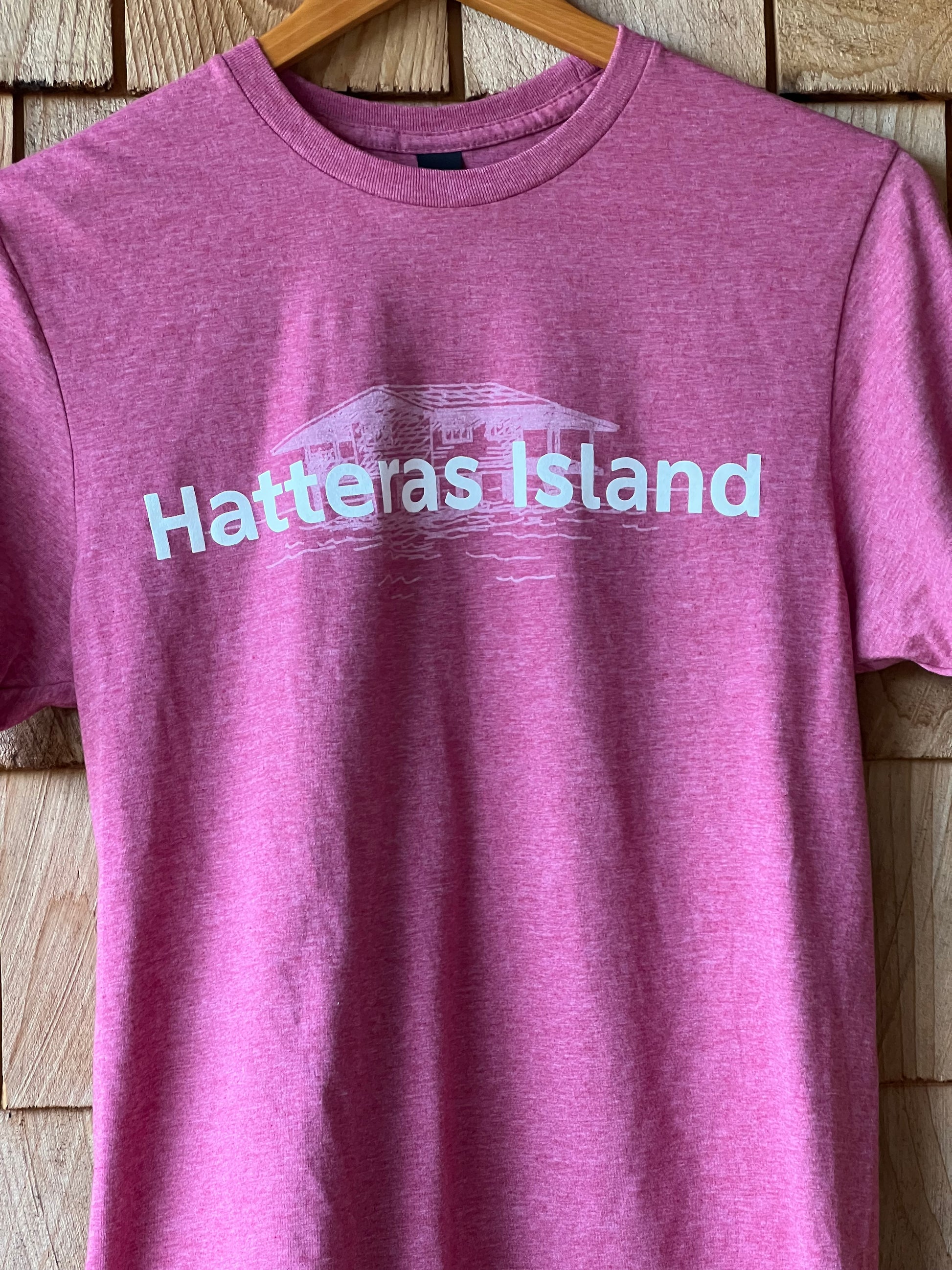 Purple t-shirt with 'Hatteras Island' text on a wooden surface