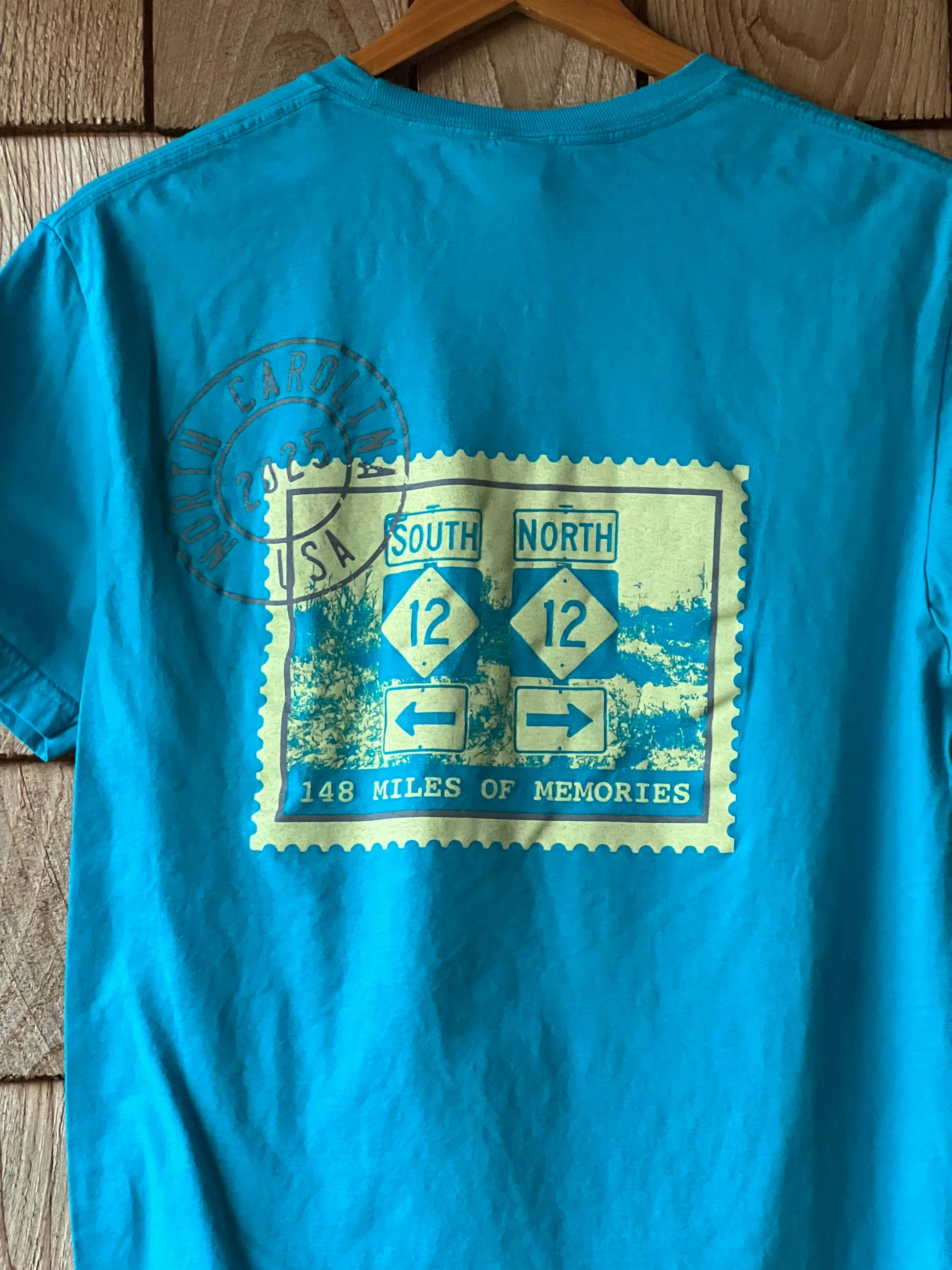 Blue t-shirt with a graphic design on a wooden surface