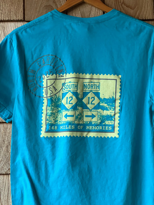 Blue t-shirt with a graphic design on a wooden surface