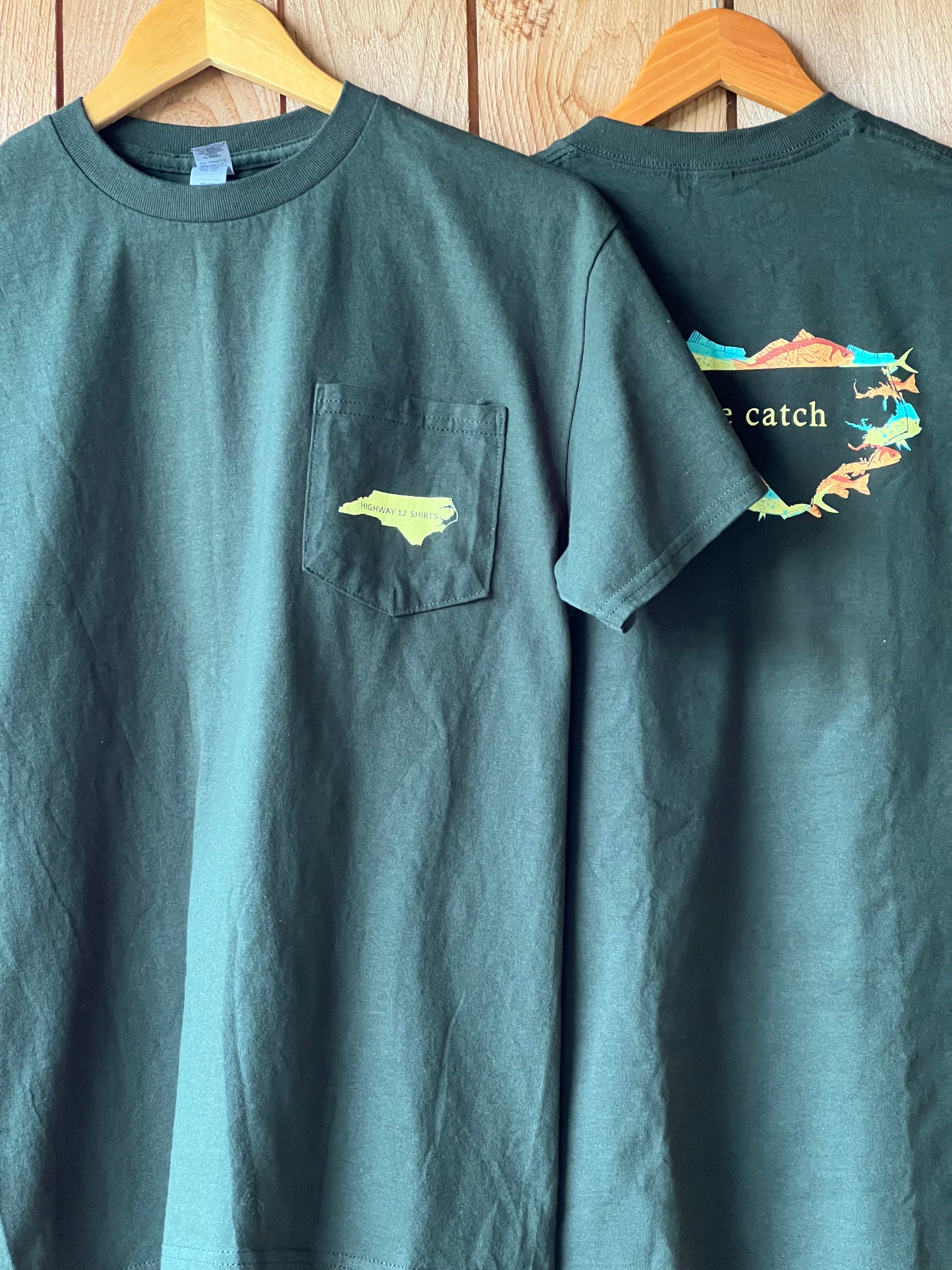 Green t-shirt with a small pocket design on a wooden surface