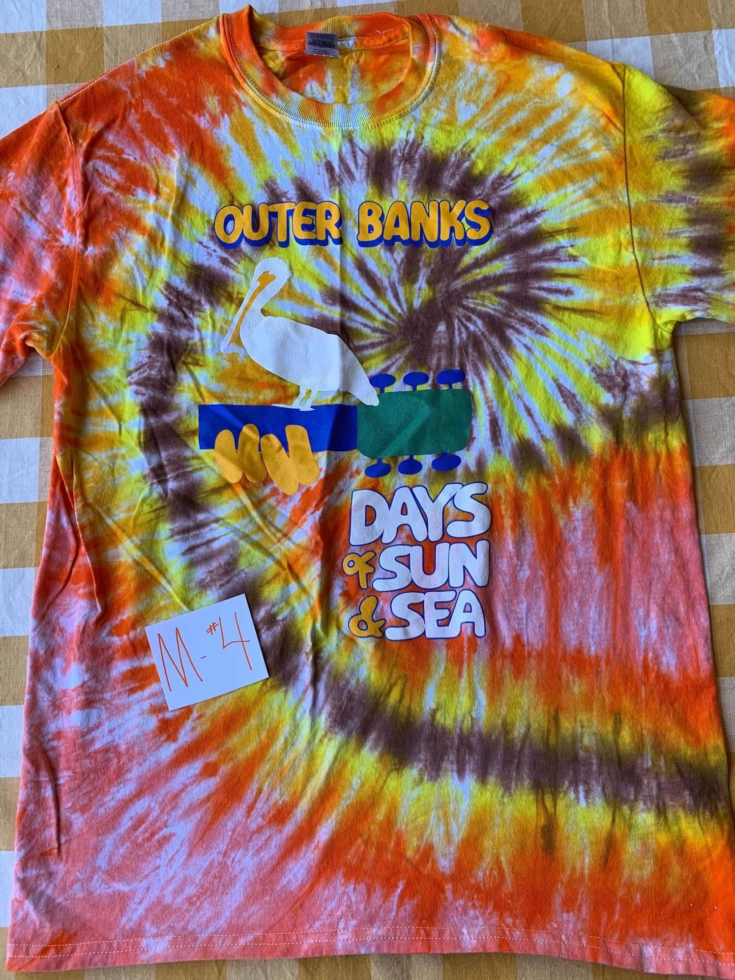 Tie-dye t-shirt with 'Outer Banks Days of Sun & Sea' design on a checkered background