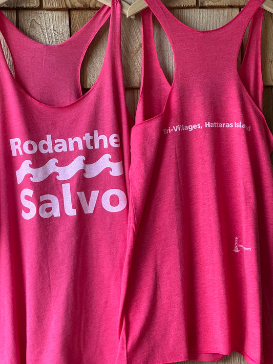 Two pink tank tops with a logo and text on a wooden surface