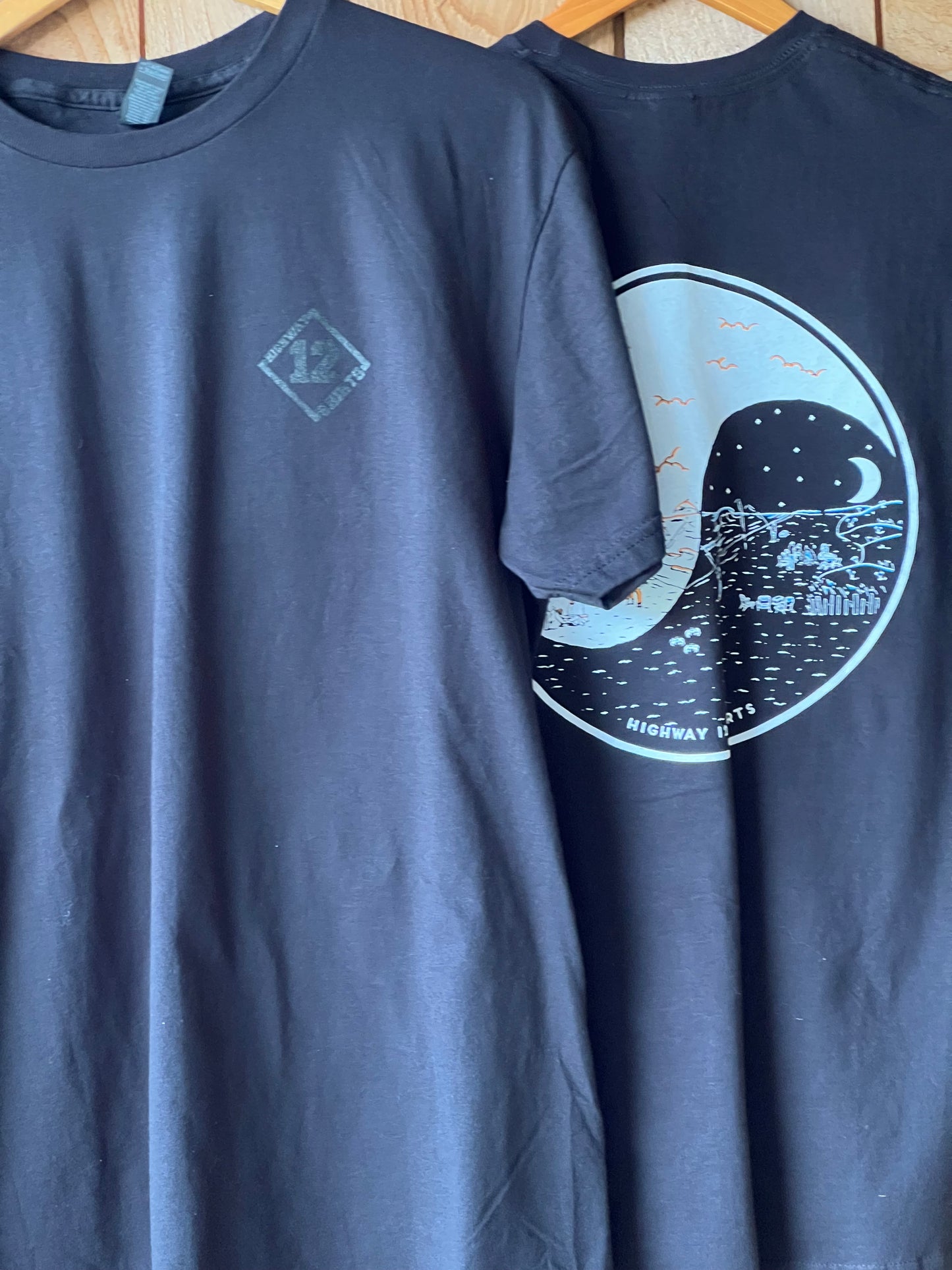 Black sleeveless shirt with a white graphic design on a wooden surface